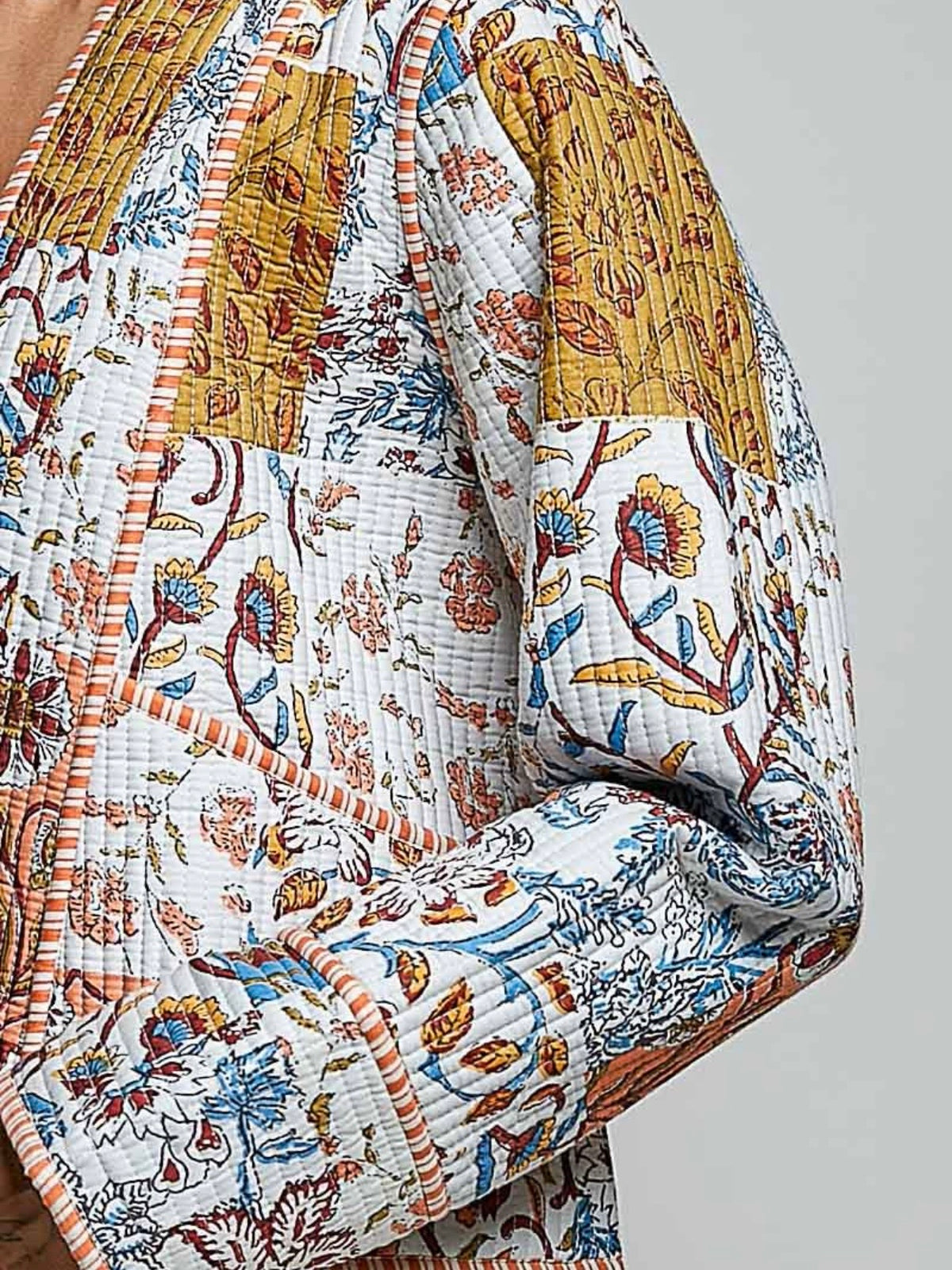 Chaqueta acolchada de mezclilla azul claro con detalles bordados de flores blancas