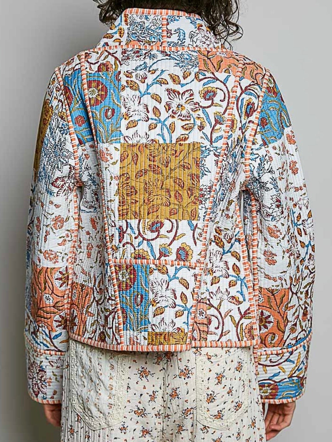 Chaqueta acolchada de mezclilla azul claro con detalles bordados de flores blancas