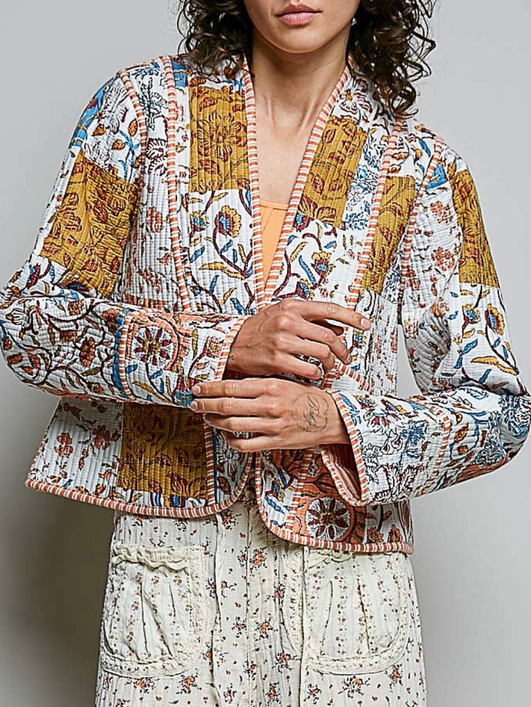 Chaqueta acolchada de mezclilla azul claro con detalles bordados de flores blancas