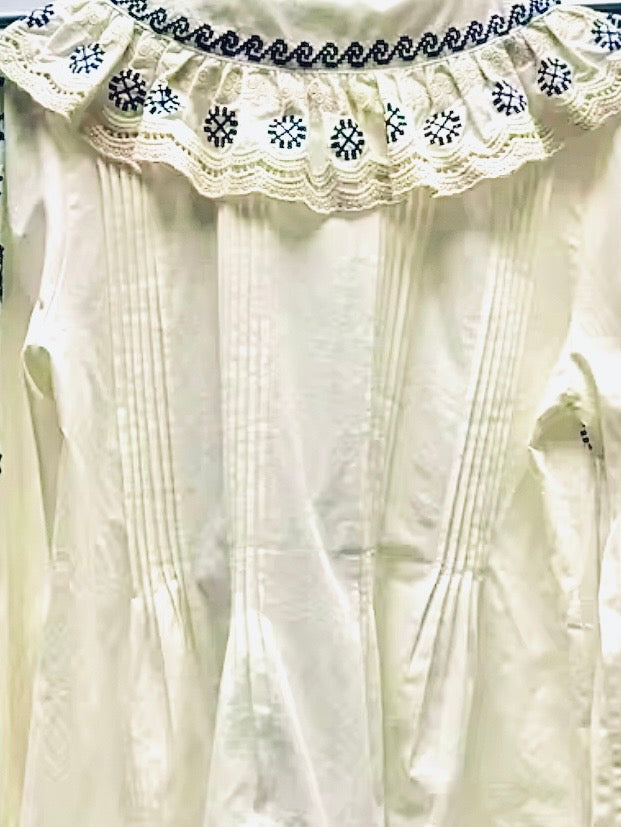Camisa de cuello amplio con volantes y detalles en blanco roto y azul claro