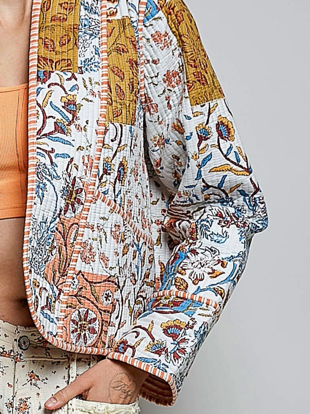 Chaqueta acolchada de mezclilla azul claro con detalles bordados de flores blancas