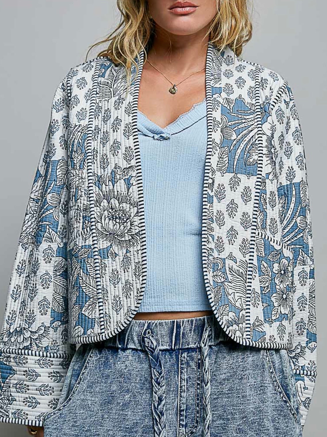 Chaqueta acolchada de mezclilla azul claro con detalles bordados de flores blancas