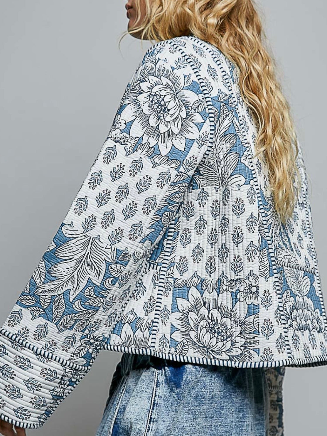 Chaqueta acolchada de mezclilla azul claro con detalles bordados de flores blancas