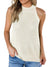 Model wears a beige tank top and halter neck in combination with jeans